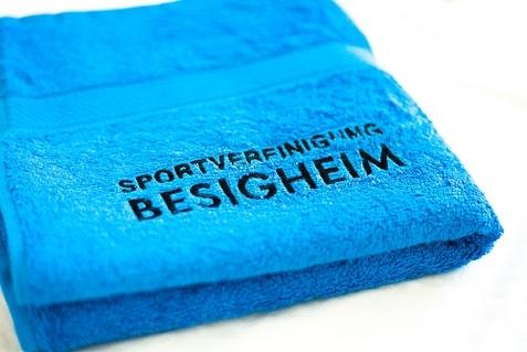 Blaues Handtuch mit dem Aufdruck „Sportverlegung Besigheim“ auf einem weißen Hintergrund.