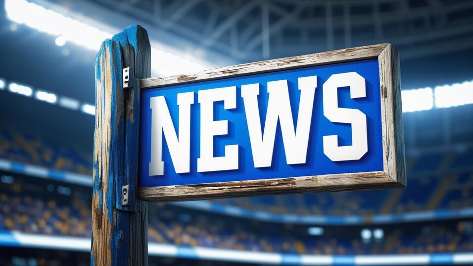 Holzschild mit dem Wort "NEWS" in großen, weißen Buchstaben vor einem unscharfen Stadionhintergrund.